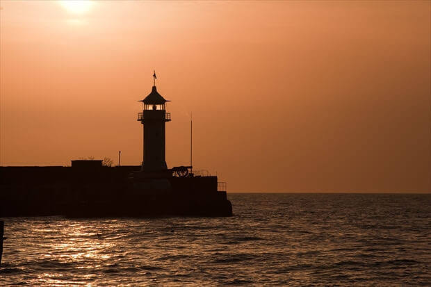 夕暮れの海辺に立つ灯台